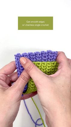 two hands are holding a green and purple crochet pot holder