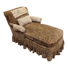 a leopard print chaise lounge chair with pillows on it's back and foot rest