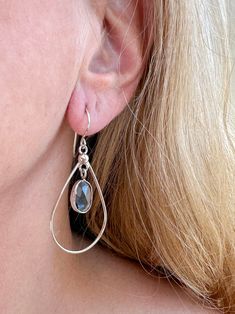 Light and airy, this earring features the clear Blue Topaz rosecut cabachon set in a fine silver bezel and delicately hanging from the handmade components. It features a surrounding teardrop shaped frame and sterling silver ball design all hanging from delicate ear wires. Each piece of GreenHillJewelry is handmade in our El Dorado Hills, CA studio. We proudly use Recycled Sterling Silver. Please allow for natural variations that may occur. This order will ship in 1-2 business days via first clas Sterling Silver Teardrop Pendant With Ear Wire, Sterling Silver Teardrop Pendant Jewelry With Ear Wire, Sterling Silver Gemstone Teardrop Earrings, Teardrop Bezel Set Jewelry, Pierced Teardrop Drop Earrings In Sterling Silver, Sterling Silver Teardrop Dangle Earrings With Pearl Drop, Sterling Silver Briolette Teardrop Gemstone Earrings, Sterling Silver Dangle Earrings With Bezel Setting, Teardrop Blue Topaz Earrings