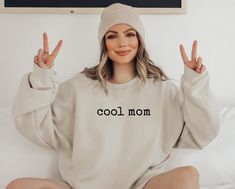 Funny Cool Mom Sweatshirt, Cute Mom Sweatshirt, Gift for Mom, Mother's Day Gift, Xmas Gift for Mom, Birthday Gift for Mom, New Mom Shirt *JUST RELEASED* * Custom Design * Limited Edition * *This item is NOT available in stores* Show your Mom love with this custom, limited edition "cool mom" sweatshirt.  Ideal for any situation, a unisex heavy blend crewneck sweatshirt is pure comfort. These garments are made from polyester and cotton. This combination helps designs come out looking fresh and beautiful. The collar is ribbed knit, so it retains its shape even after washing. There are no itchy side seams on these sweaters.  .: Made with a medium-heavy fabric blend of 50% cotton and 50% polyester (8.0 oz/yd² (271.25 g/m this sweatshirt feels cozy and is the perfect choice for those colder mont Cool Cotton Winter Tops, Cool Cotton Tops For Winter, Cool Crew Neck Tops For Winter, Casual Slogan Sweatshirt For Mother's Day, Casual Mother's Day Slogan Sweatshirt, Casual Winter Birthday Sweatshirt, Winter Birthday Tops With Graphic Print, Casual Cotton Sweatshirt For Birthday, Winter Birthday Top With Graphic Print