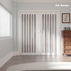 an empty room with white walls and wooden furniture in the corner, along with vertical blinds on the sliding glass doors