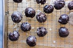 chocolate donuts on a cooling rack with white sprinkles and water droplets