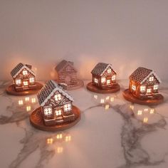 five lit up houses sitting on top of a marble counter next to each other in front of a white wall