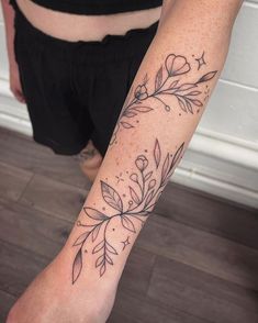 a woman's arm with flowers and stars tattooed on the left side of her body