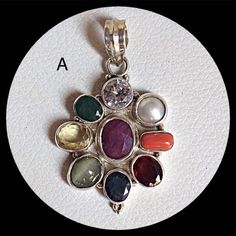 Genuine 925 Sterling Silver Navratan Pandent  Gemstone - Ruby , Emerald , Blue Sapphire, Yellow Sapphire, Hessonite, Cats Eye, Coral, Pearl, Cubic Zircona.  Stones setted - 9 pieces Quantity - 1 PC. No. - A.  No. - B. No. - C.  QTY - 1 piece in this listing. The navratna or nine gems influencing the nine planets are:  Ruby  =  Sun ,  Pearl = Moon, Red Coral = Mars, Emerald = Mercury,  Yellow Sapphire = Jupiter, zircon = Venus, Blue Sapphire = Saturn,  Hessonite = Rahu , Cat''s Eye = Ketu . Multicolor Spiritual Jewelry With Stone Setting, Healing Birthstone Pendant Gemstone, Traditional Multi-stone Gemstones As Gift, Traditional Multi-stone Gemstones For Gifts, Fusion Style Oval Sterling Silver Gemstones, Silver Fusion Jewelry With Stones, Multi-stone Sterling Silver Jewelry As Gift, Fusion Style Silver Jewelry With Stones, Traditional Natural Gemstones As Gifts