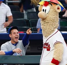 a baseball player and a mascot giving each other high fives