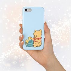 a person holding up a phone case with a cartoon bear on the front and bottom