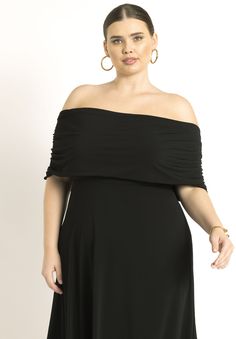 a woman in a black dress posing for the camera with her hands on her hips