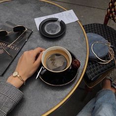 a person sitting at a table with a cup of coffee