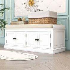 a white cabinet with drawers and a basket on top in front of a blue wall