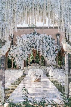 an outdoor wedding setup with white flowers and greenery on the aisle, surrounded by chairs