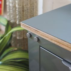 a close up view of a metal cabinet with wood trim and knobs on it