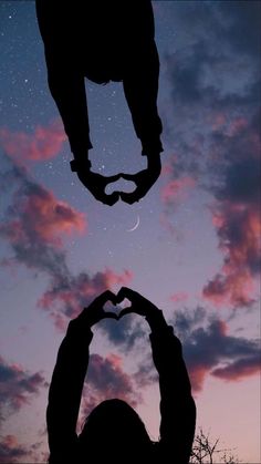 two hands making a heart shape in the sky