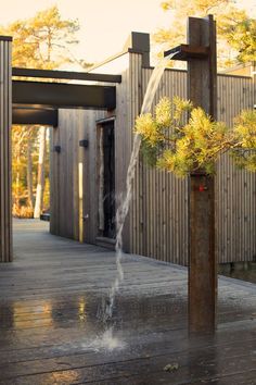 a water spouting out of a wooden pole on top of a wooden deck