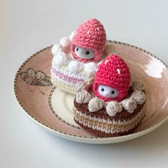 two small crocheted cakes sitting on top of a plate