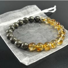 ❤️ Genuine Gemstone Stretchable Bracelet Made to Order with Pyrite and Citrine Crystals with 14K Gold Filled Accent Bead This Abundance Bracelet is a potent amulet for good fortune made of Citrine & Pyrite crystals, which give it metaphysical strength. When worn, it is supposed to attract wealth, success, and abundance to the wearer. PYRITE Pyrite is a powerful protection stone which shields and protects against all forms of negative vibrations and/or energy, working on the physical, etheric, an Pyrite Bracelet, Bracelet Gift Box, Zodiac Bracelet, Crystal Healing Bracelets, White Bracelets, Attract Wealth, Citrine Crystal, Amethyst Bracelet, Crystal Bracelet