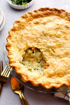 a pie sitting on top of a table next to silverware