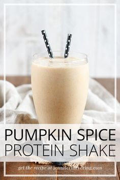 pumpkin spice protein shake in a glass with two straws sticking out of the top