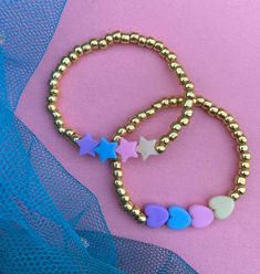 These fun bracelets are stylish and chic for young girls. Perfect for stocking stuffers, birthday gifts, friendship bracelets, the list can go on. Bracelet listing includes one bracelet of your choice. If you would like different colored beads than the gold please send me a message Pair with our other stacking bracelets to make a cute custom stack! PRODUCT DETAILS: - Bracelets are made with stretchy quality jewelry elastic - All orders are FINAL SALE as they are custom orders. Please double chec Trendy Heart Beads Jewelry For Birthday, Trendy Heart Beaded Jewelry For Birthday, Trendy Gold Friendship Bracelets For Valentine's Day, Cute Handmade Gold Beaded Bracelets, Playful Heart Beads Jewelry For Friendship, Trendy Hypoallergenic Bracelets For Valentine's Day, Trendy Hypoallergenic Bracelet For Valentine's Day, Cute Personalized Gold Stretch Bracelet, Gold Heart-shaped Beaded Bracelet For Birthday