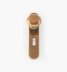 an antique brass door handle with a keyhole on the front and back side, against a white background