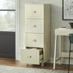 a white filing cabinet sitting next to a window