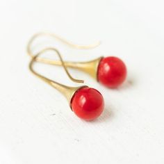 A beautiful pair of Red Coral dangle earrings measuring 1" long from tip to tip, the stone measures 8mm and the ear wires are antique brass.The details:Dangle earringsBrass earringsBRed corals 1" longShipped in a gift box Red Brass Earrings With Ear Wire, Red Brass Drop Earrings, Nickel-free Red Brass Earrings, Coral Earring, Coral Drop Earrings, Red Coral Earrings, Interchangeable Earrings, Arrow Earrings, Black Onyx Earrings