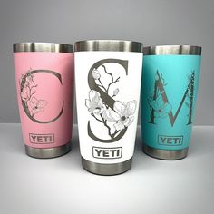 three different colored yeti cups sitting next to each other