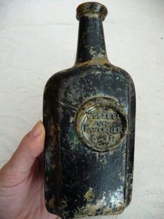 an old bottle that is in someone's hand