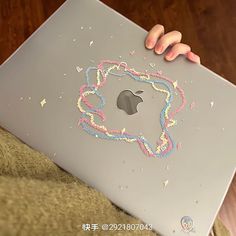 a person holding an apple laptop covered in confetti