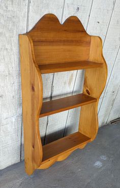 a wooden shelf sitting on top of a cement floor