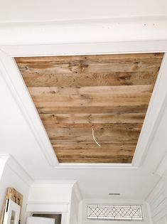 a wooden ceiling in a room with white walls and wood planks on the ceiling