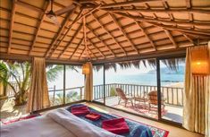 a bed sitting under a wooden roof next to a window