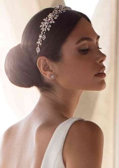 a woman in a white dress wearing a tiara with pearls on the head and shoulders