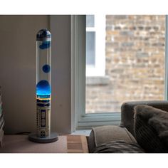 a blue and white lamp sitting on top of a table next to a window