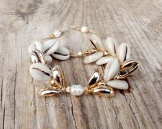 This beautiful cowrie shell bracelet is made with natural beige cowrie shells, natural gold cowrie shells, gold plated beads, natural pearls and beige silk cord. Bead size: shell 1,5 - 2 cm / 0,6 - 0,8 inch.; gold plated beads 0,3 cm /0,1 inch. Your bracelet comes gift wrapped and shipped via priority registered air mail with tracking info available. Feel free to ask me any questions! Thanks for visiting and happy shopping :) Cowrie Shell Bracelet, Cowrie Shell Jewelry, Neon Bracelets, Double Bracelet, Beige Silk, Cowrie Shells, Jewelry Summer, Jewelry Beach, Shell Bracelet