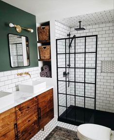 a white toilet sitting next to a walk in shower under a bathroom mirror above a sink