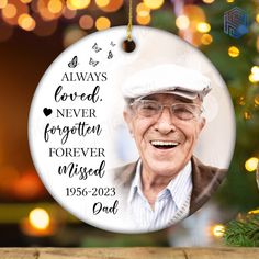 a christmas ornament with an image of a smiling elderly man in front of a christmas tree