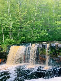 a large waterfall in the middle of a forest