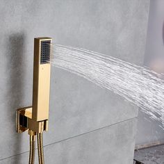 an open shower head with water coming out of it's spout, on a grey wall