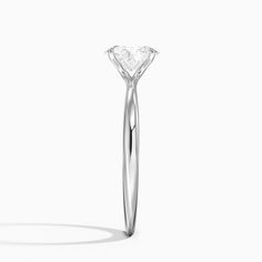 a diamond ring on a white background with the shadow of it's head in the foreground