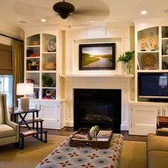 a living room filled with furniture and a fire place next to a tv mounted on a wall