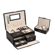 an open black leather jewelry box with three drawers and two rings in the bottom drawer