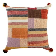 a multicolored pillow with pom - poms on the front and sides