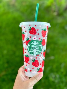 someone holding up a starbucks cup with strawberries on it