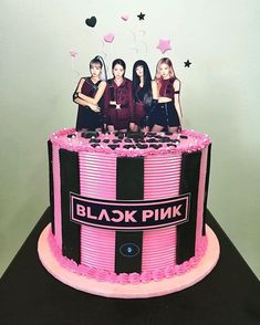 a pink and black striped cake with four women on top, surrounded by balloons in the shape of stars