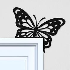 a black butterfly on the wall next to a white door