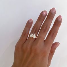 a woman's hand with pink manicures and a ring on her finger