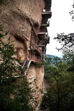 a cliff side with several balconies on the top and stairs leading up to them