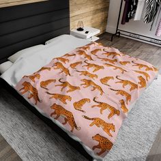 a bed with a pink and orange cheetah print on it