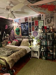 a bed room with a neatly made bed and lots of posters on the wall above it